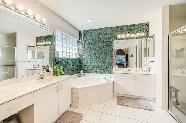 bathroom featuring a bath, tile patterned flooring, a stall shower, and a sink