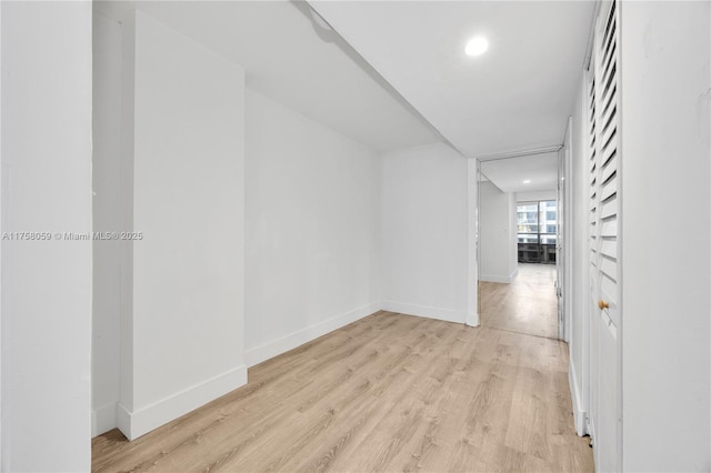 corridor featuring recessed lighting, light wood-type flooring, and baseboards