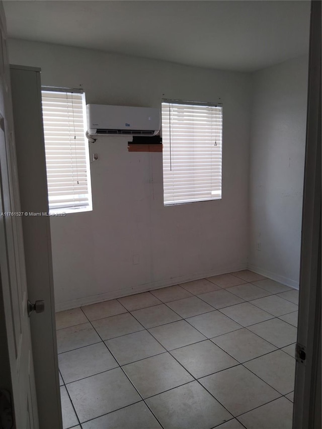 unfurnished room featuring a wall mounted air conditioner, baseboards, and a wealth of natural light