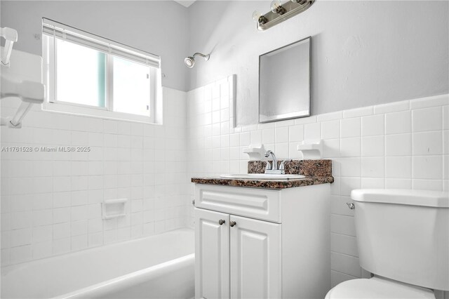 521 NE 82nd Ter, Miami, FL 33138 - bathroom featuring toilet, tile walls, washtub / shower combination, wainscoting, and vanity