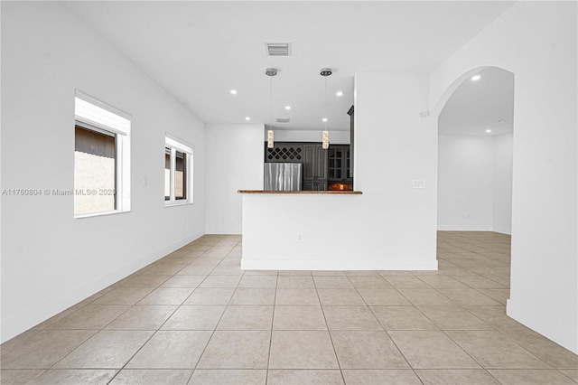 spare room with arched walkways, visible vents, recessed lighting, and light tile patterned floors