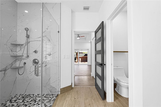 full bathroom featuring a marble finish shower, visible vents, toilet, and wood finished floors