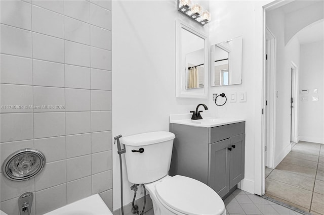 bathroom with toilet, vanity, and tile patterned flooring