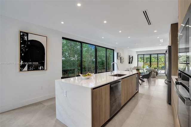 kitchen with modern cabinets, recessed lighting, appliances with stainless steel finishes, a sink, and open floor plan