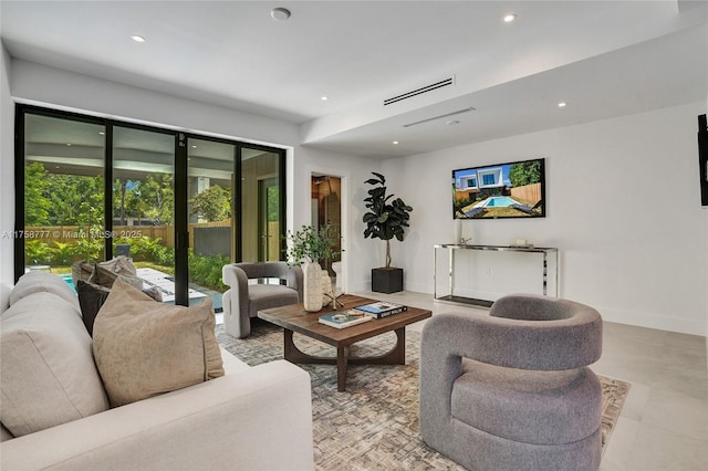 living area with baseboards, visible vents, and recessed lighting
