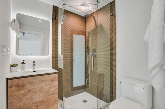 full bath with toilet, vanity, and a shower stall