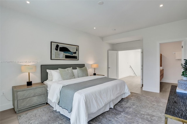 bedroom with baseboards, wood finished floors, and recessed lighting