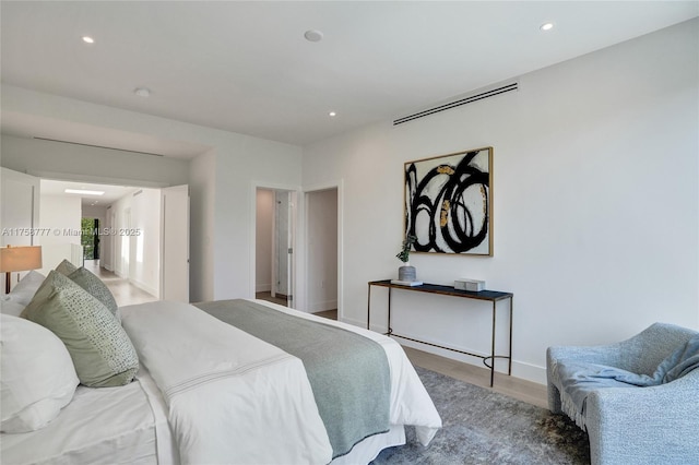 bedroom featuring baseboards, wood finished floors, and recessed lighting