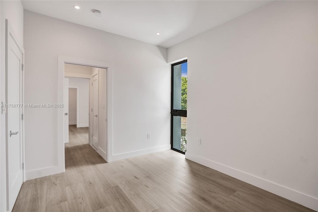unfurnished room featuring light wood finished floors, baseboards, and recessed lighting