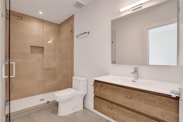 full bathroom featuring toilet, vanity, tiled shower, and visible vents