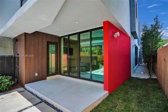 doorway to property with fence and a patio