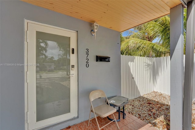 property entrance featuring stucco siding and fence