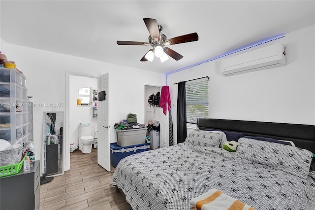 bedroom featuring a ceiling fan, light wood-style floors, and a wall unit AC