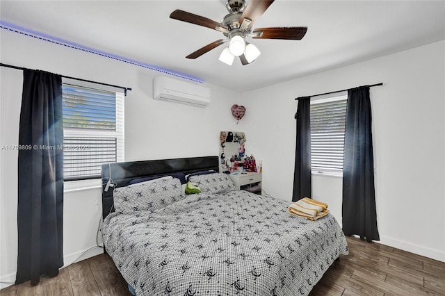 bedroom with baseboards, a ceiling fan, a wall unit AC, and wood finished floors