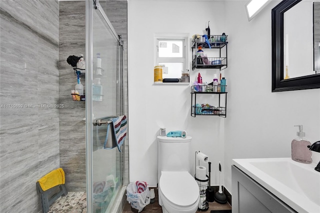 full bath with a stall shower, toilet, and vanity