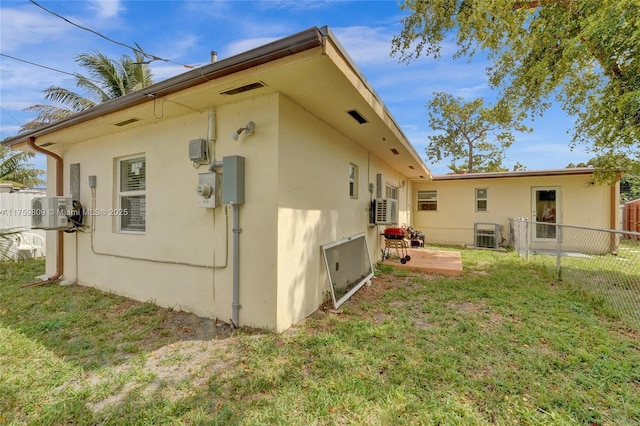 view of property exterior with a patio, a yard, fence, and stucco siding