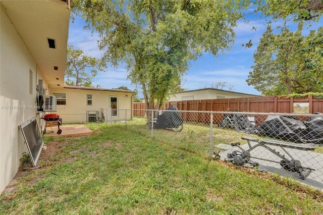 view of yard featuring central AC unit, a fenced backyard, and a patio