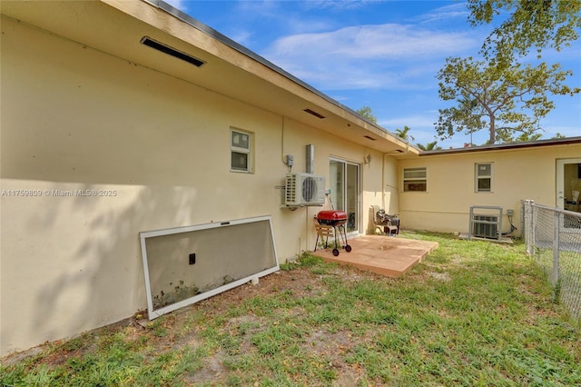 back of property featuring ac unit, stucco siding, fence, a yard, and a patio area