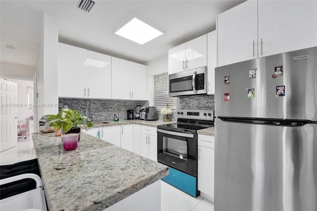 kitchen with stainless steel appliances, tasteful backsplash, visible vents, and a peninsula