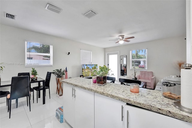 kitchen with light tile patterned floors, visible vents, and white cabinets