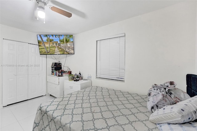 tiled bedroom with a closet and a ceiling fan