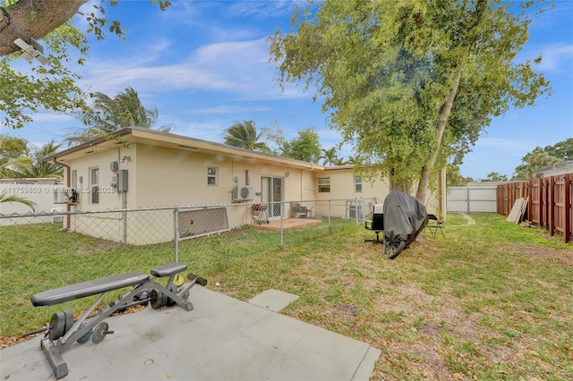 rear view of property with a patio, a yard, a fenced backyard, and stucco siding