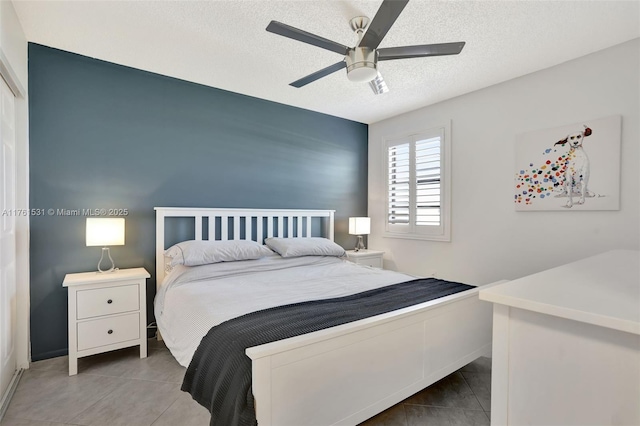 bedroom with tile patterned floors, a textured ceiling, and a ceiling fan