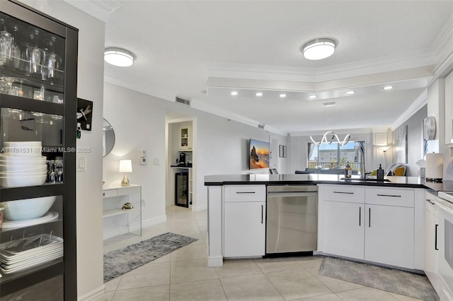 kitchen featuring dark countertops, visible vents, dishwasher, ornamental molding, and a sink