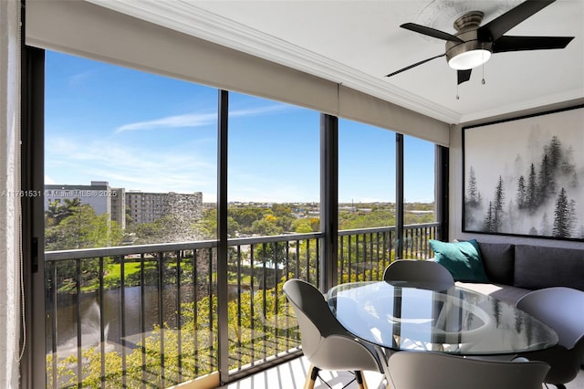 sunroom / solarium featuring a city view and ceiling fan