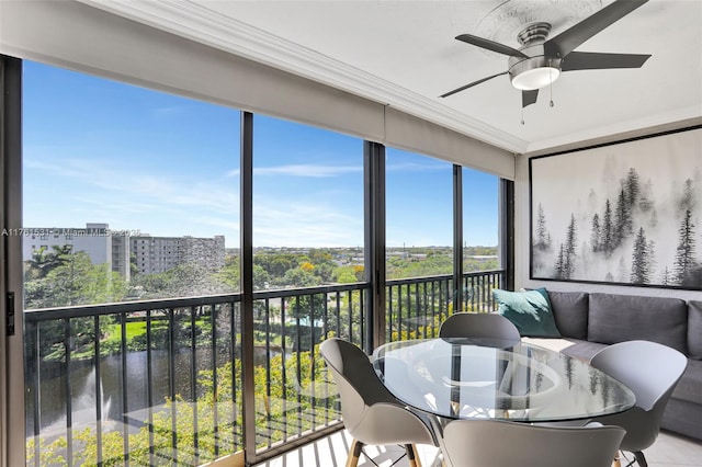 sunroom with plenty of natural light, a view of city, and ceiling fan