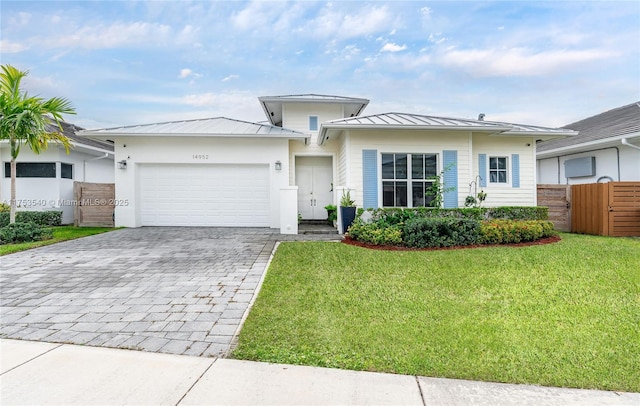 14952 SW 177th Ter, Miami, FL 33187 - view of front of property featuring a front yard, a standing seam roof, a garage, decorative driveway, and metal roof