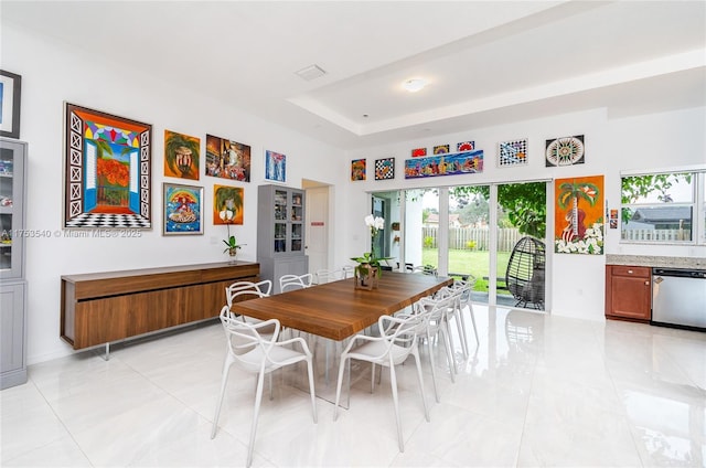 dining area featuring visible vents and a raised ceiling