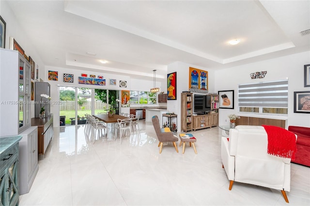 living area with visible vents and a raised ceiling