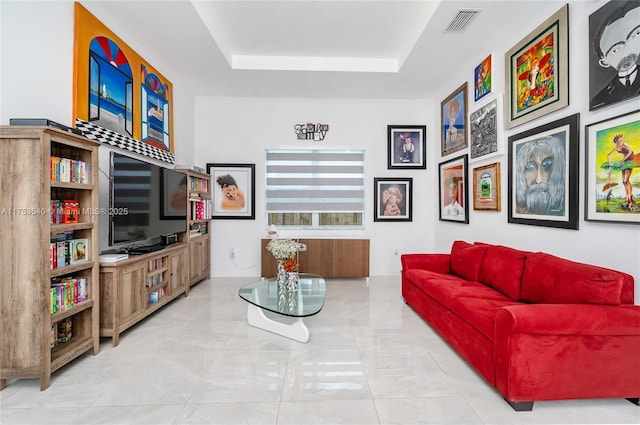 living area featuring a raised ceiling and visible vents