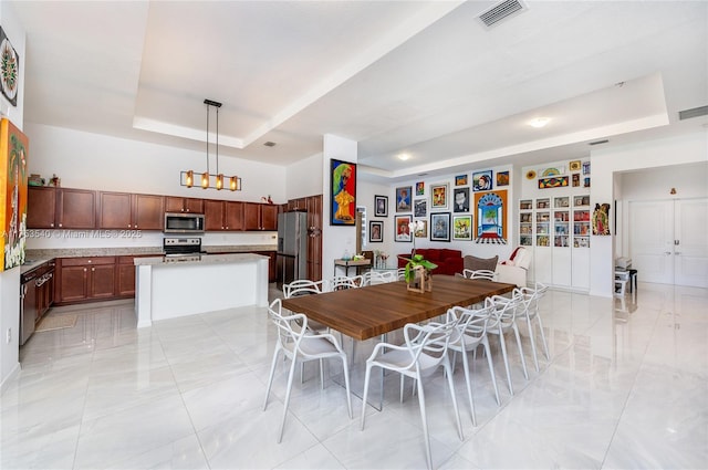 dining room featuring a raised ceiling and visible vents