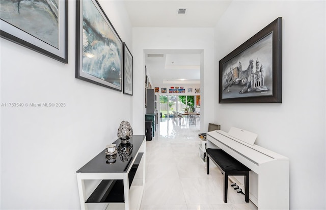 hallway featuring light tile patterned floors and visible vents