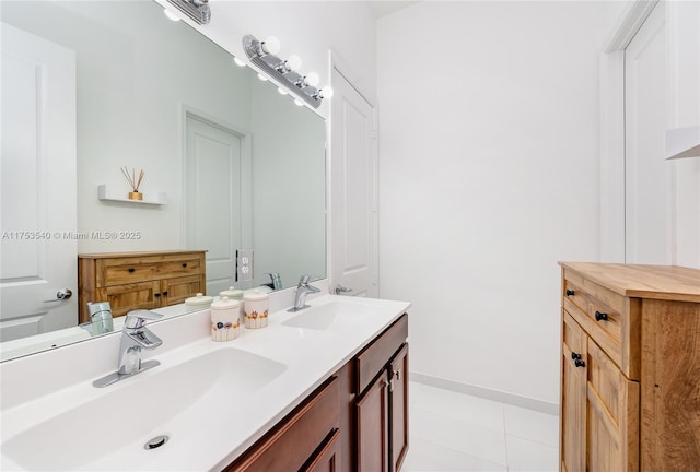 full bath featuring tile patterned flooring, double vanity, baseboards, and a sink