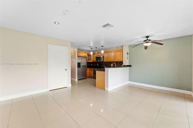 kitchen featuring visible vents, tasteful backsplash, dark countertops, appliances with stainless steel finishes, and a peninsula