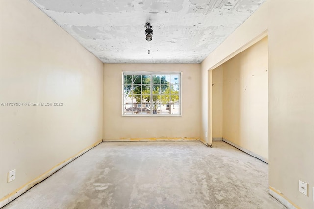 unfurnished room featuring unfinished concrete flooring