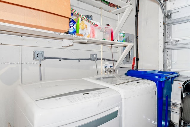 clothes washing area featuring laundry area, a garage, and washer and clothes dryer