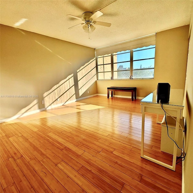 bonus room featuring ceiling fan, baseboards, wood-type flooring, and a textured ceiling