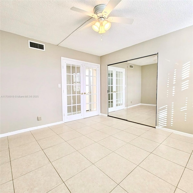 spare room with visible vents, light tile patterned floors, french doors, a textured ceiling, and a ceiling fan