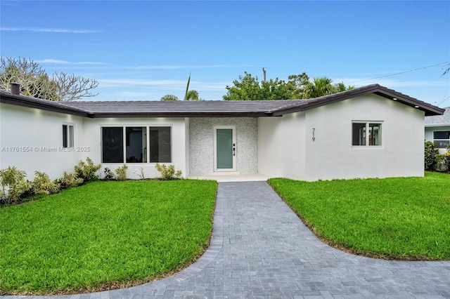 ranch-style house featuring a front yard and stucco siding