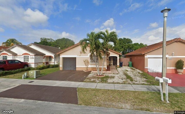 view of front facade featuring stucco siding, a garage, and aphalt driveway