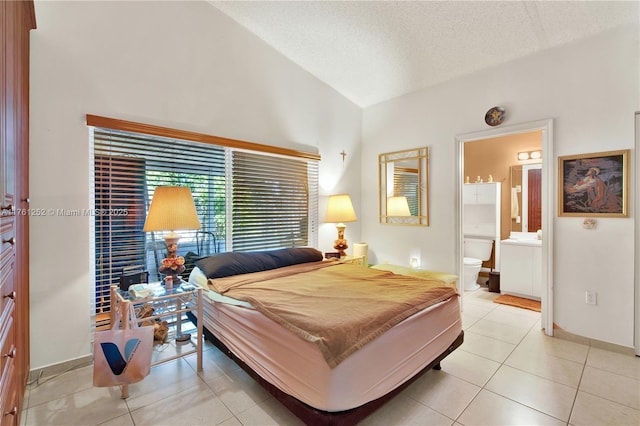 bedroom featuring light tile patterned floors, baseboards, lofted ceiling, ensuite bathroom, and a textured ceiling