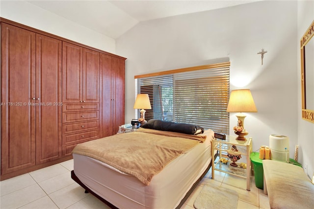 bedroom with lofted ceiling and light tile patterned floors