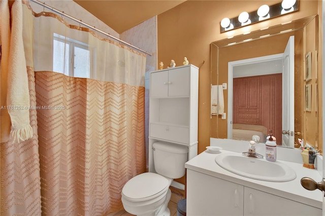 bathroom featuring vanity, curtained shower, and toilet