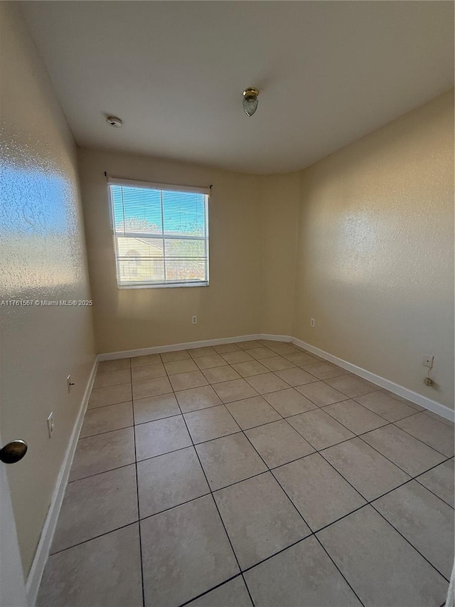 spare room with baseboards