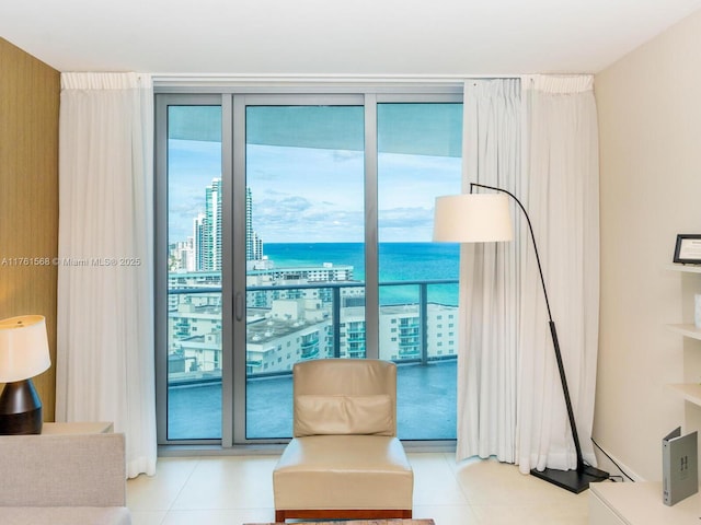 living area with tile patterned floors, a city view, and a wall of windows