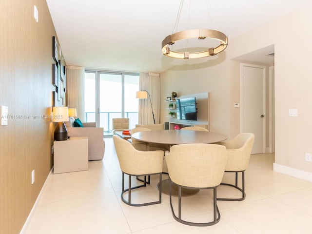 dining space with light tile patterned flooring, a wall of windows, and baseboards